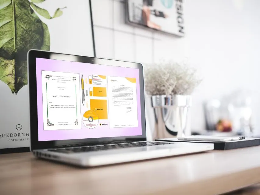 Laptop displaying a finished document on a plant-lined desk